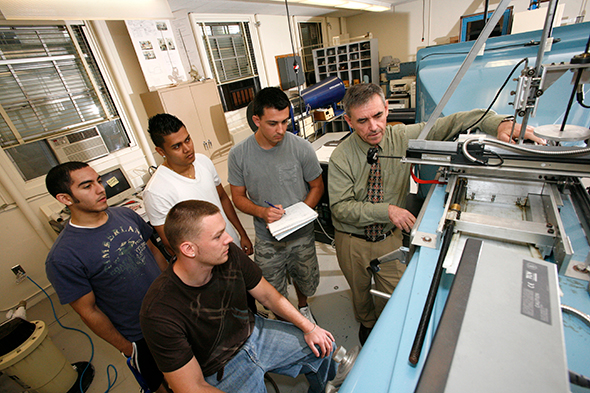 INTO Hofstra instructor demostrating machine to four students in the engineering class.